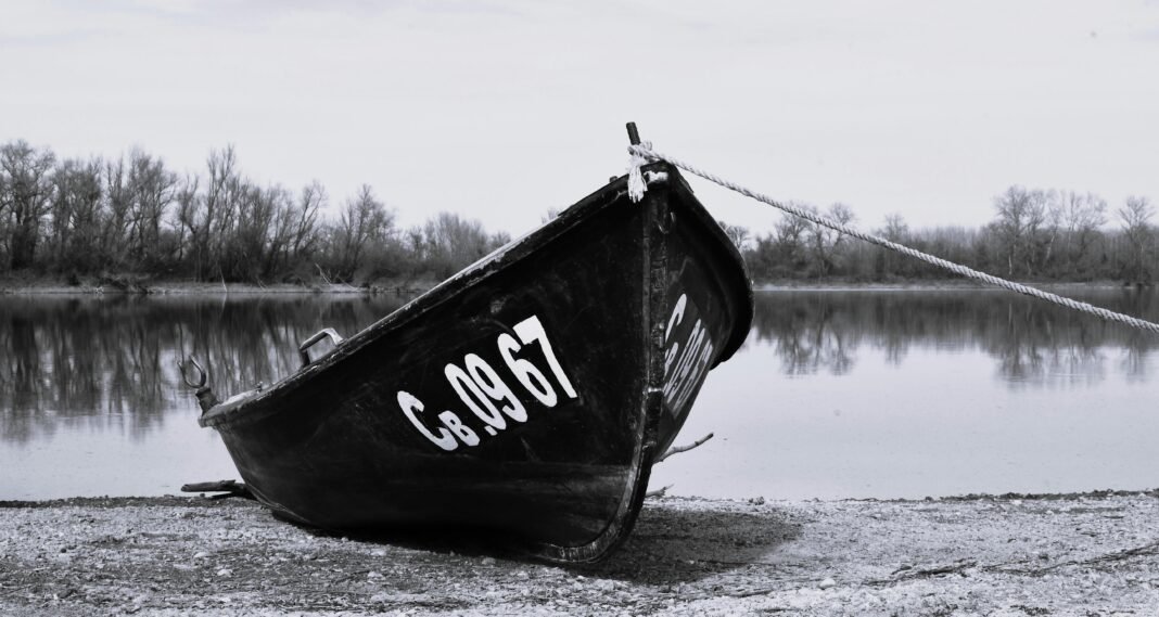 Moody black and white photo of a boat on the Danube riverbank in Bulgaria.