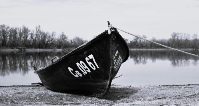 Moody black and white photo of a boat on the Danube riverbank in Bulgaria.