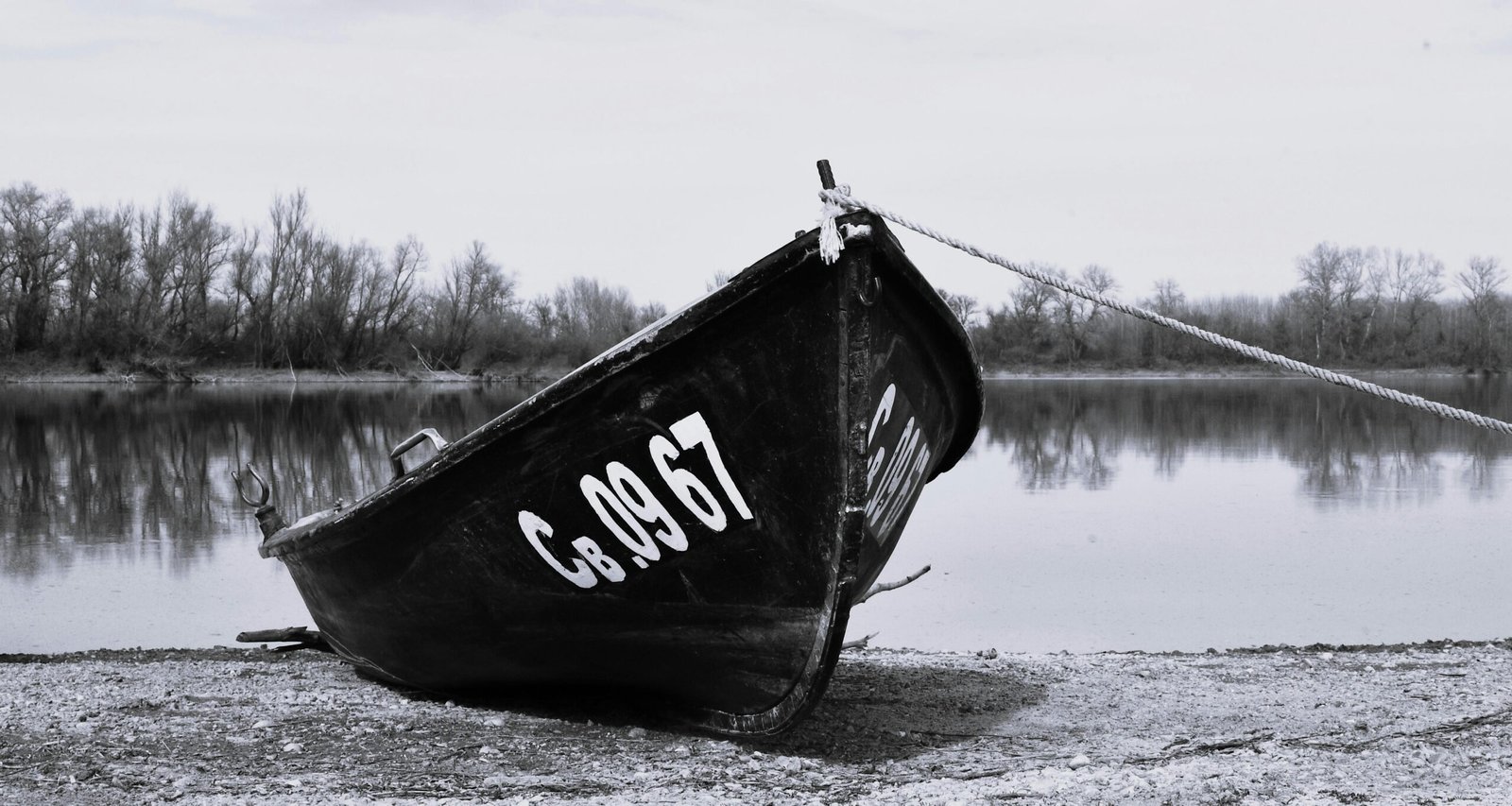 Moody black and white photo of a boat on the Danube riverbank in Bulgaria.